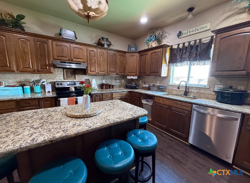 609 Highway 123 Stockdale, TX 78160 - Photo 9 of 26 a kitchen with granite countertop kitchen island stainless steel appliances a sink stove top oven and cabinets