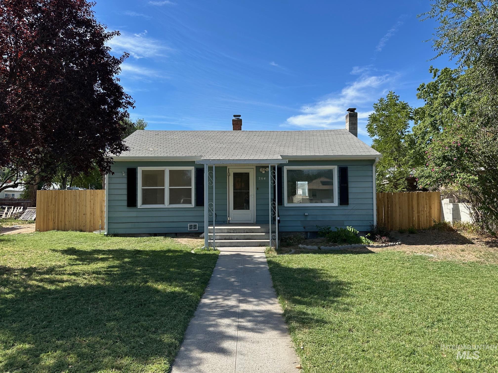 View of front of property with roof with shingles and a chimney