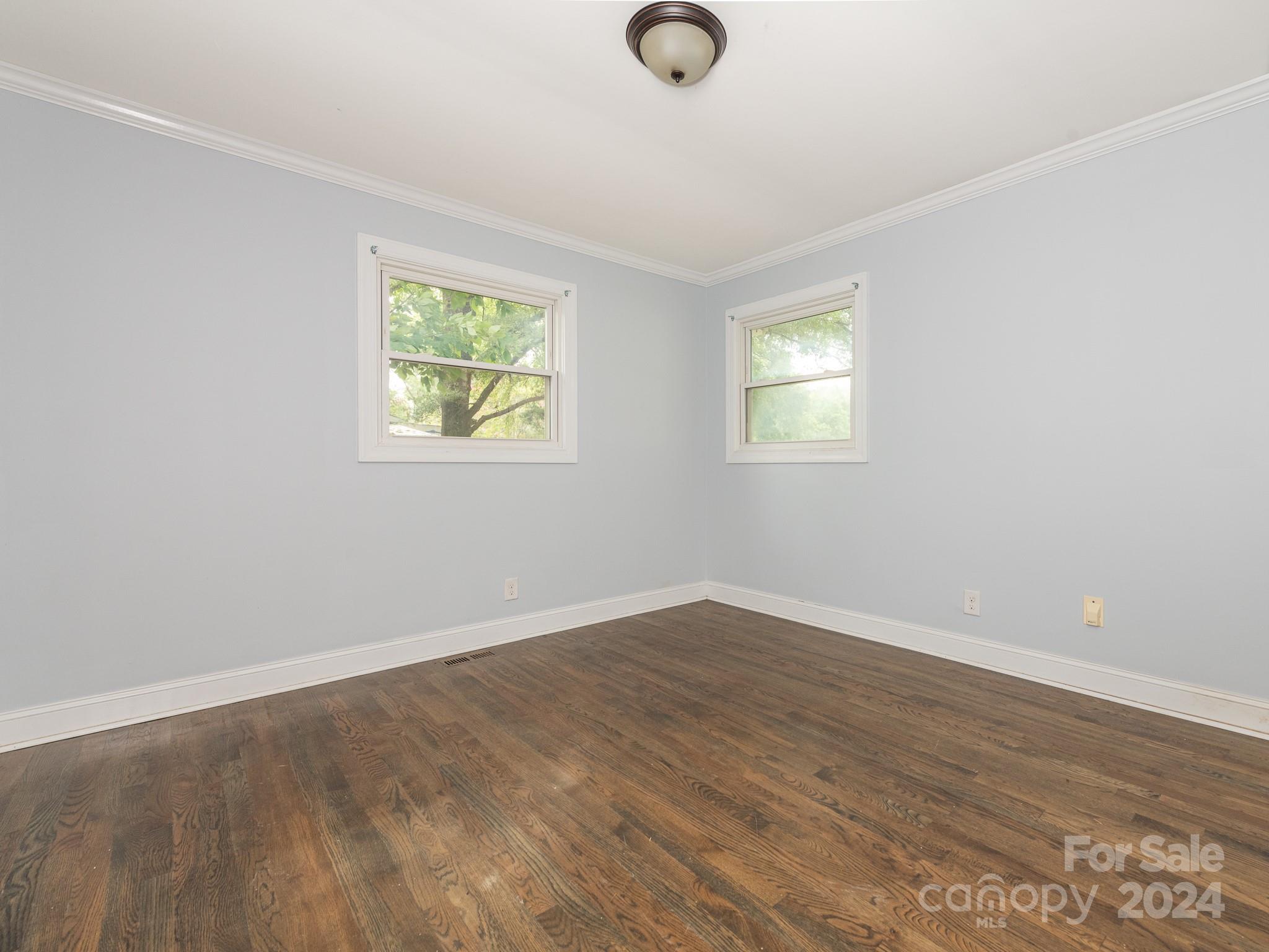 8106 Indian Trail Fairview Road Indian Trail, NC 28079 - Photo 12 of 17 an empty room with wooden floor and windows