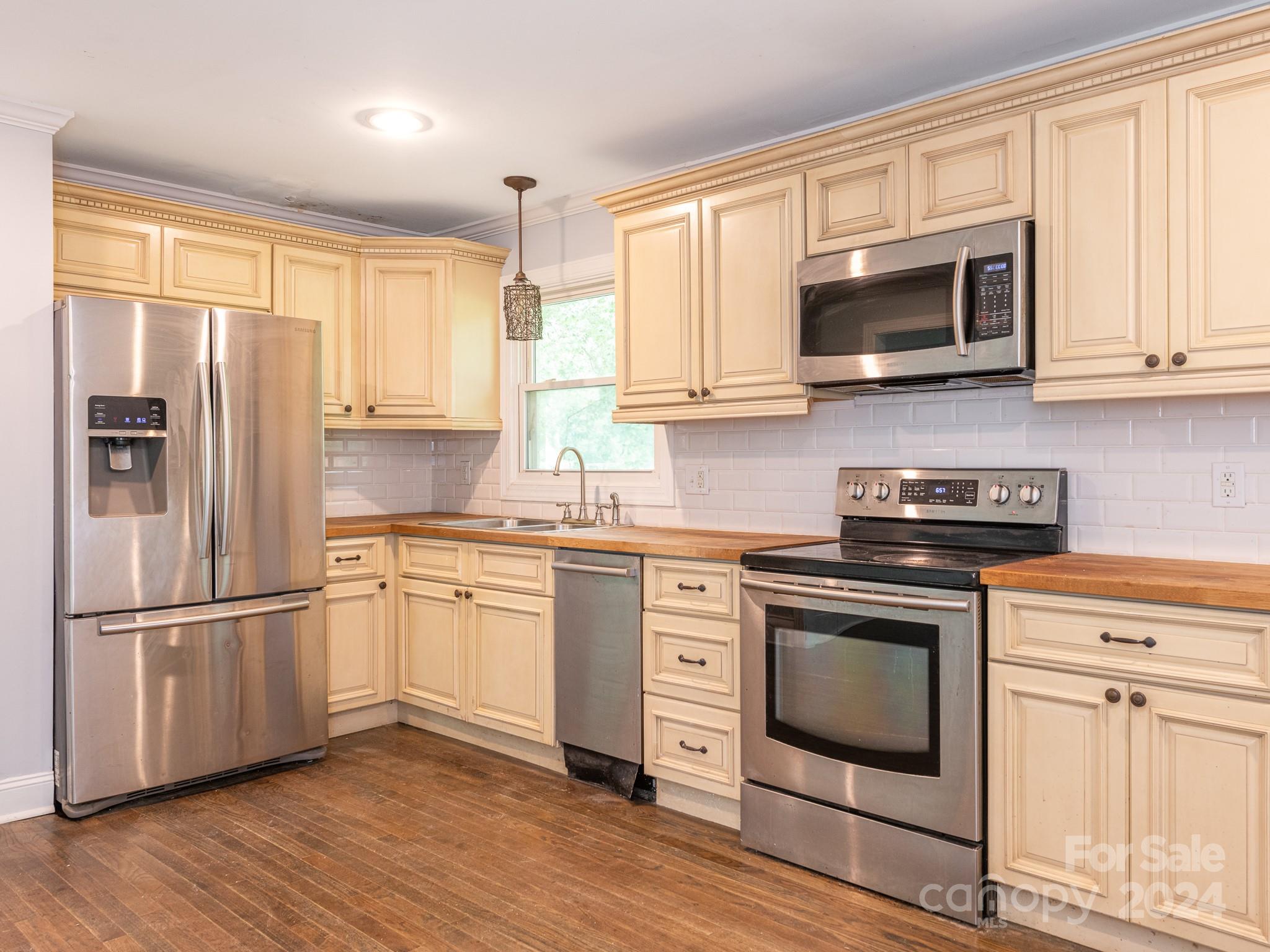 8106 Indian Trail Fairview Road Indian Trail, NC 28079 - Photo 3 of 17 a kitchen with cabinets stainless steel appliances and wooden floor