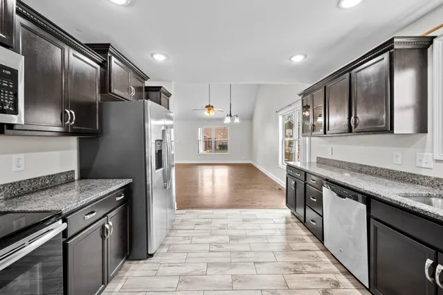 a kitchen with stainless steel appliances granite countertop a sink stove and refrigerator