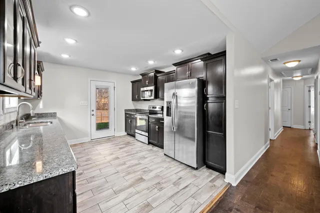 a kitchen with stainless steel appliances granite countertop a refrigerator and a sink