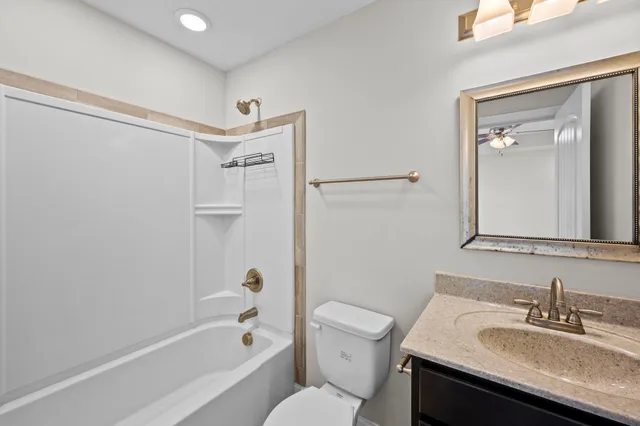 a bathroom with a sink toilet vanity and shower