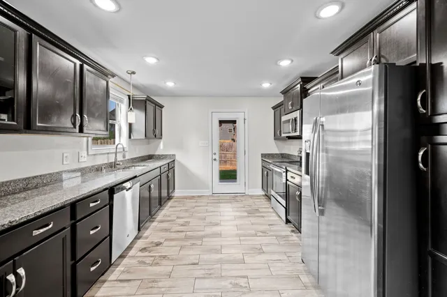 a large kitchen with a sink and refrigerator
