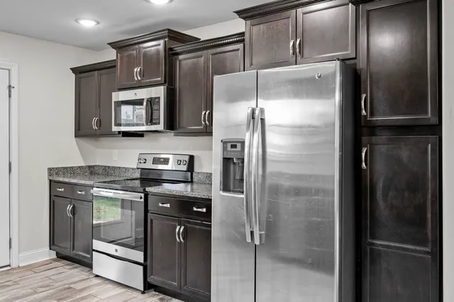 a kitchen with stainless steel appliances granite countertop a refrigerator and a sink