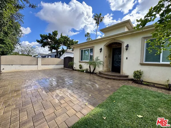 a view of a house with a yard and potted plants