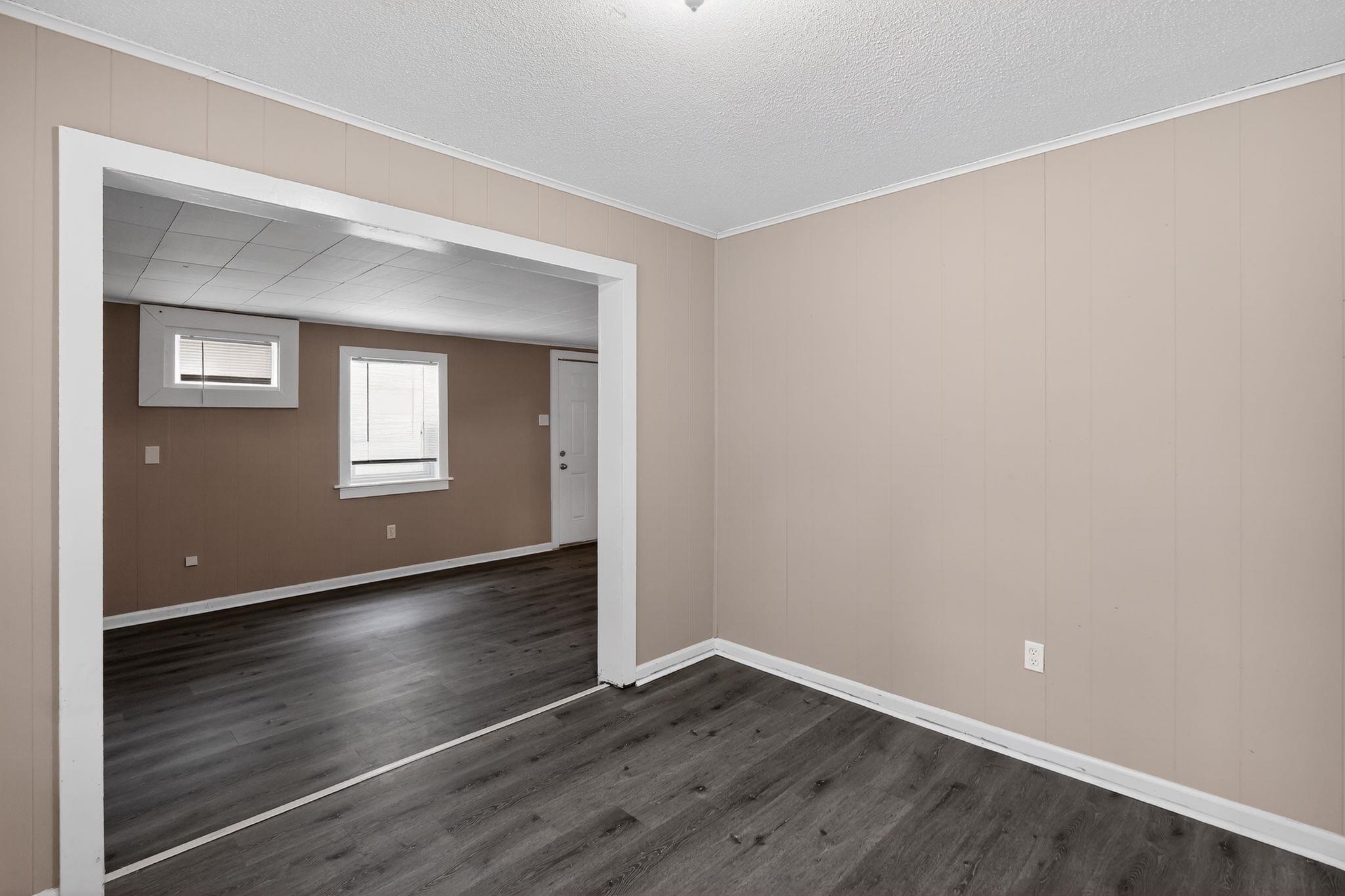 3741 Ridgemont Road Memphis, TN 38128 - Photo 17 of 32 Spare room featuring dark wood-type flooring, crown molding, a textured ceiling, and wood walls