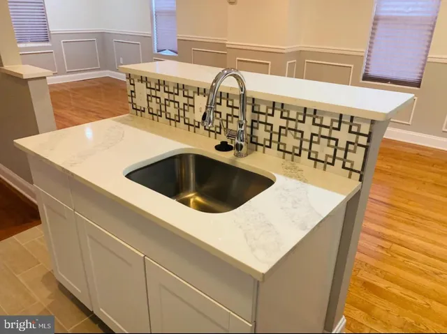 a kitchen with a sink a stove and white cabinets