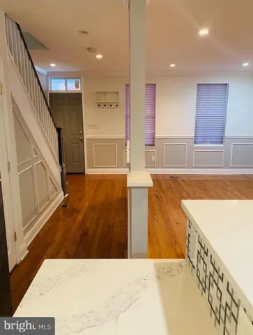 a view of a kitchen with kitchen island a sink wooden floor and living room