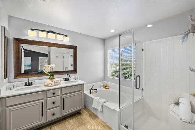 a spacious bathroom with double vanity a mirror a bathtub and a shower
