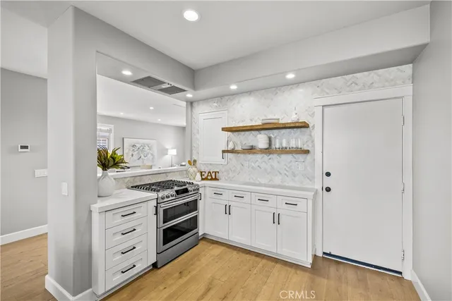 a kitchen with white cabinets and stainless steel appliances