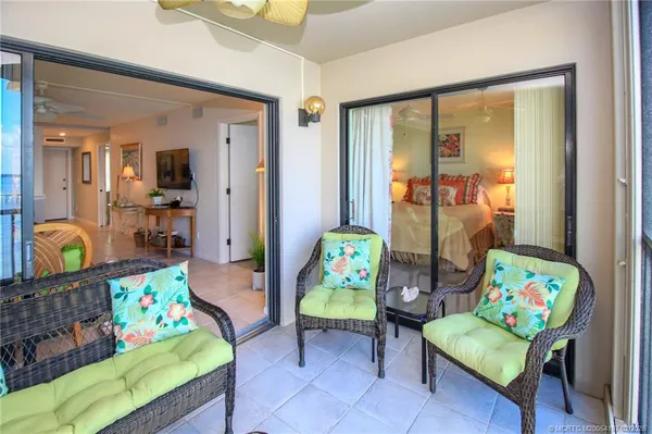 a view of a balcony with wooden floor & chairs