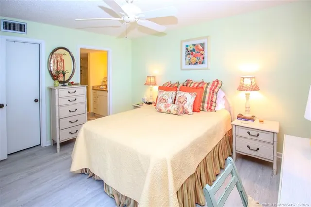 a bedroom with a bed and a flat tv screen on dresser