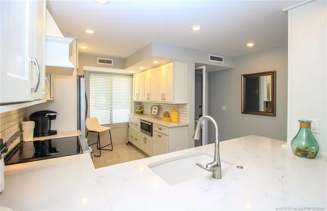 a large kitchen with a large window and dining table