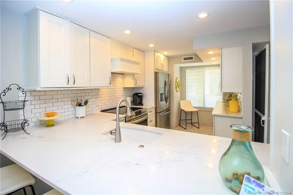 a kitchen with counter top space and living room view