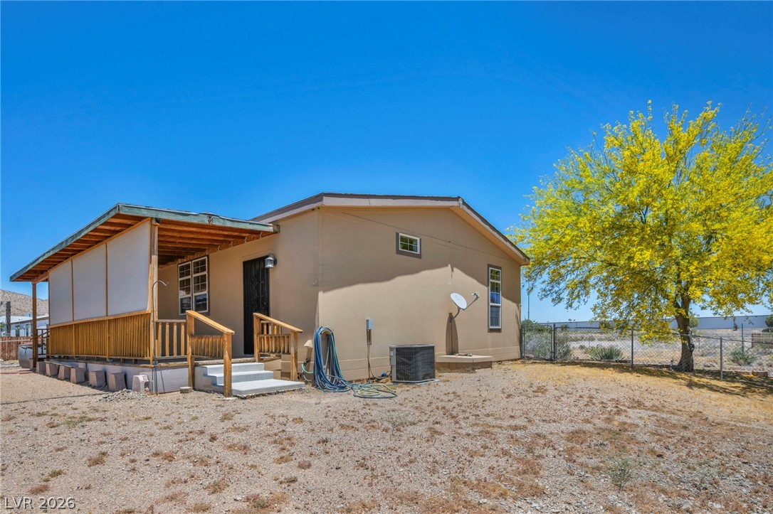 225 California Street Searchlight, NV 89046 - Photo 5 of 64 A well-maintained desert oasis awaits, offering a comfortable retreat with a covered porch.