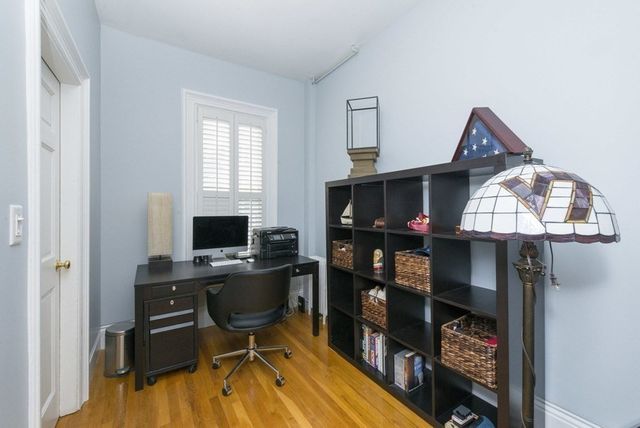 a view of a workspace with furniture and a window