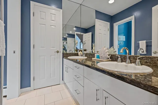 a spacious bathroom with a granite countertop sink and a mirror