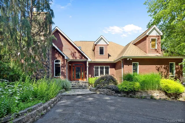 a front view of a house with a yard and potted plants