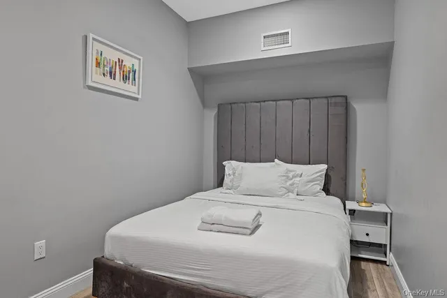 a bedroom with a bed and a wall painting