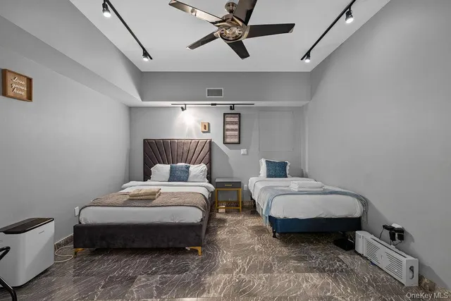 a spacious bedroom with two beds and painting on the wall