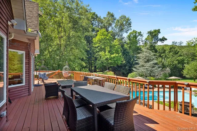a balcony with wooden floor table and chairs