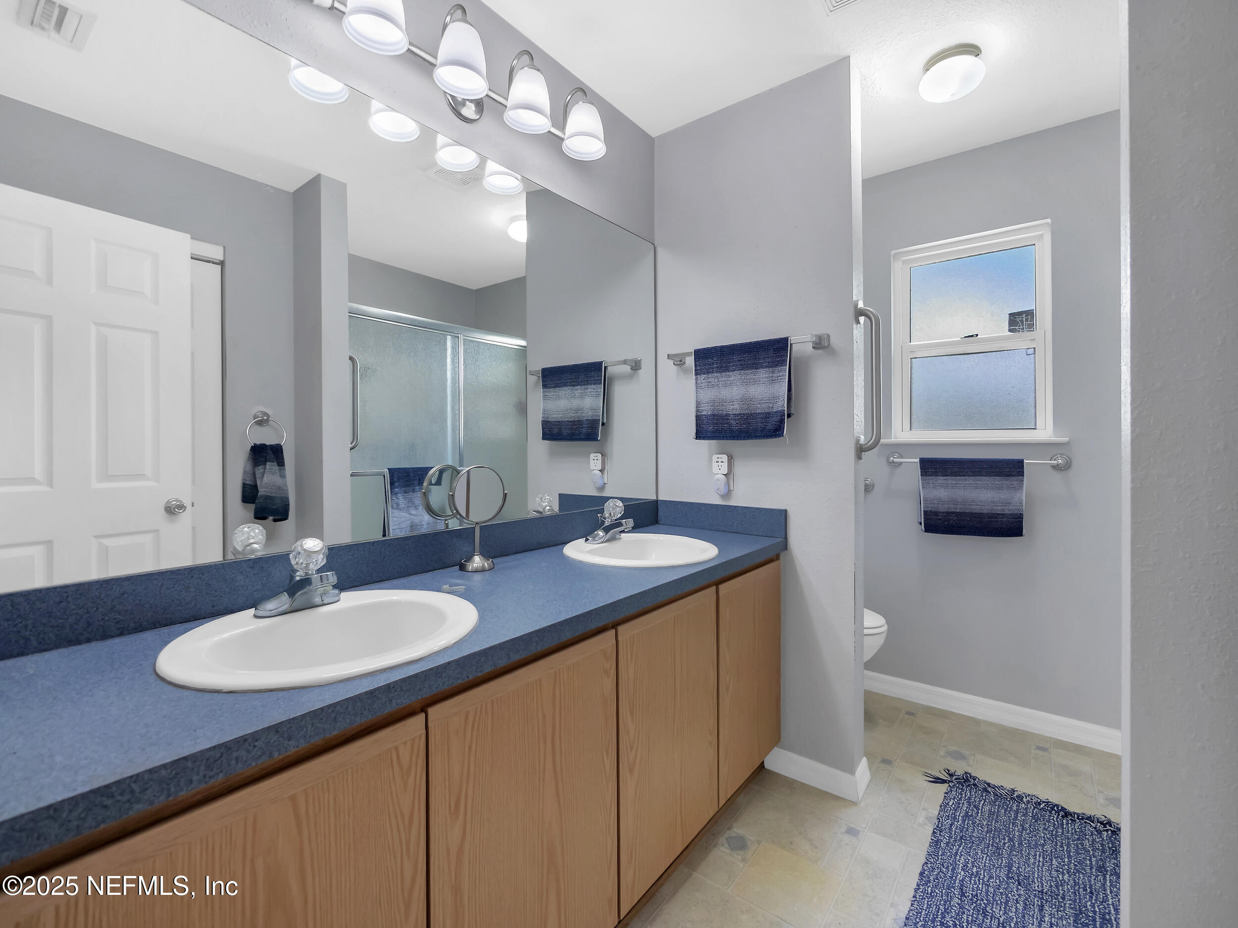 1193 4 Mile Road St. Augustine, FL 32084 - Photo 13 of 54 a bathroom with a granite countertop sink a large mirror and a toilet