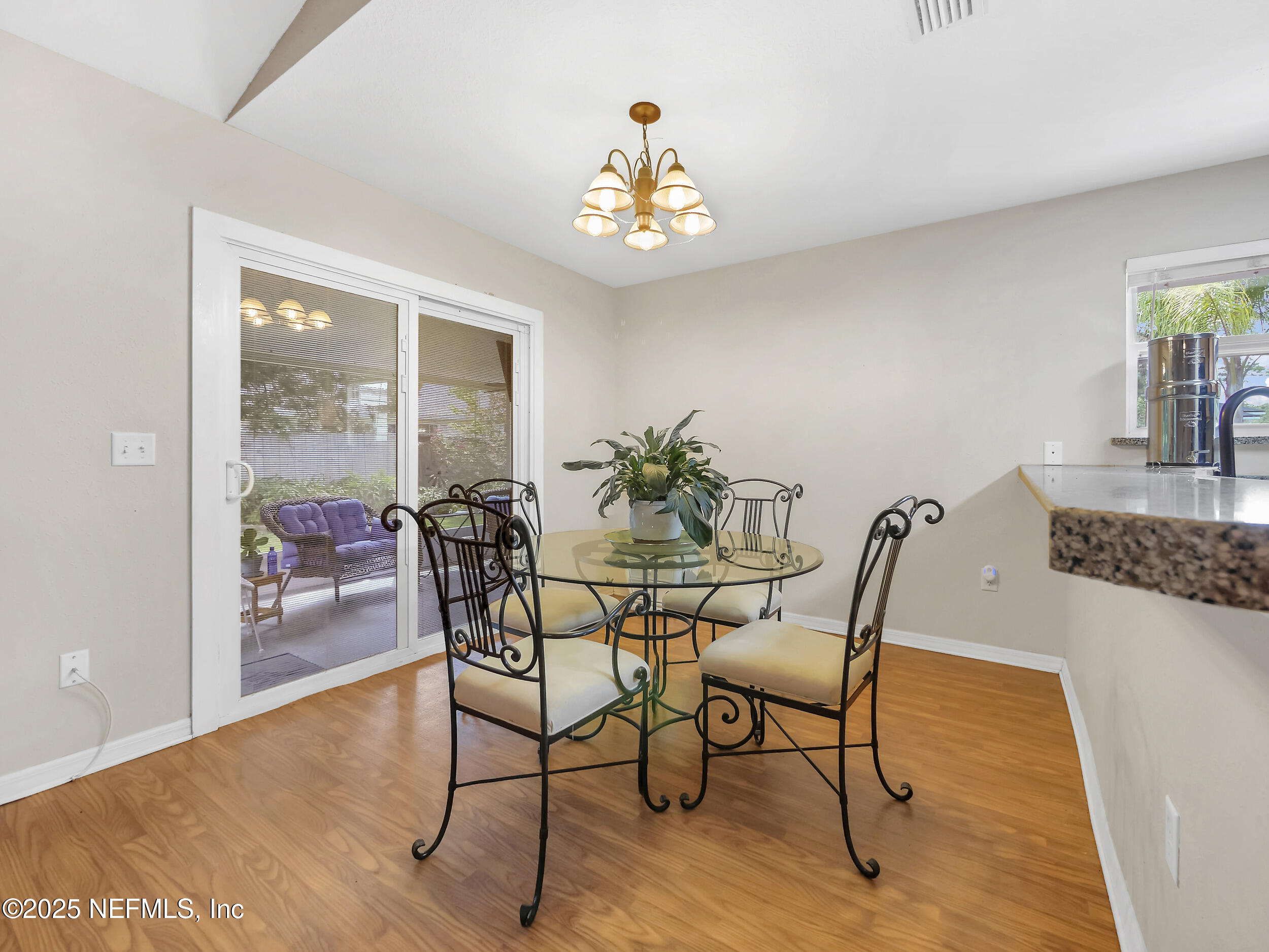 1193 4 Mile Road St. Augustine, FL 32084 - Photo 17 of 54 a view of a dining room with furniture wooden floor and a chandelier