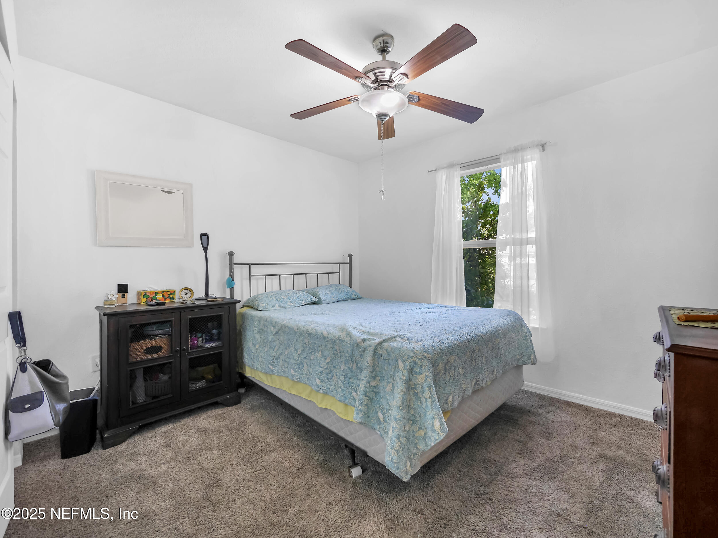 1193 4 Mile Road St. Augustine, FL 32084 - Photo 23 of 54 a bedroom with a bed and a chandelier