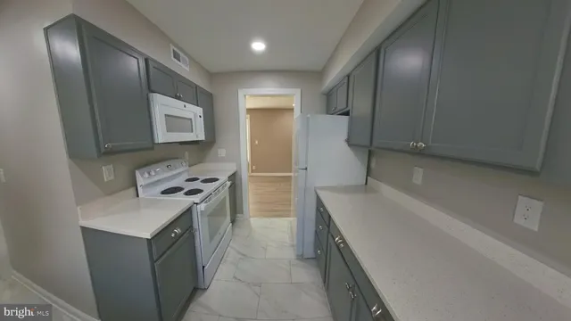 a view of an empty room with wooden floor and closet