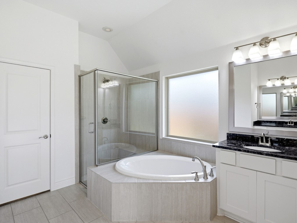 109 Lake Spring Circle Georgetown, TX 78633 - Photo 25 of 38 Indulge in a primary bathroom retreat featuring a spacious soaking tub and a sleek glass-enclosed shower.