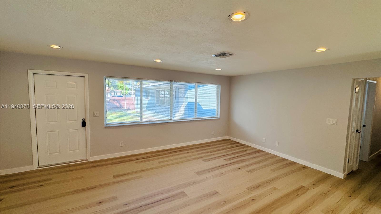 808 Northeast 2nd Street, Unit A Hallandale Beach, FL 33009 - Photo 2 of 11 an empty room with wooden floor and windows