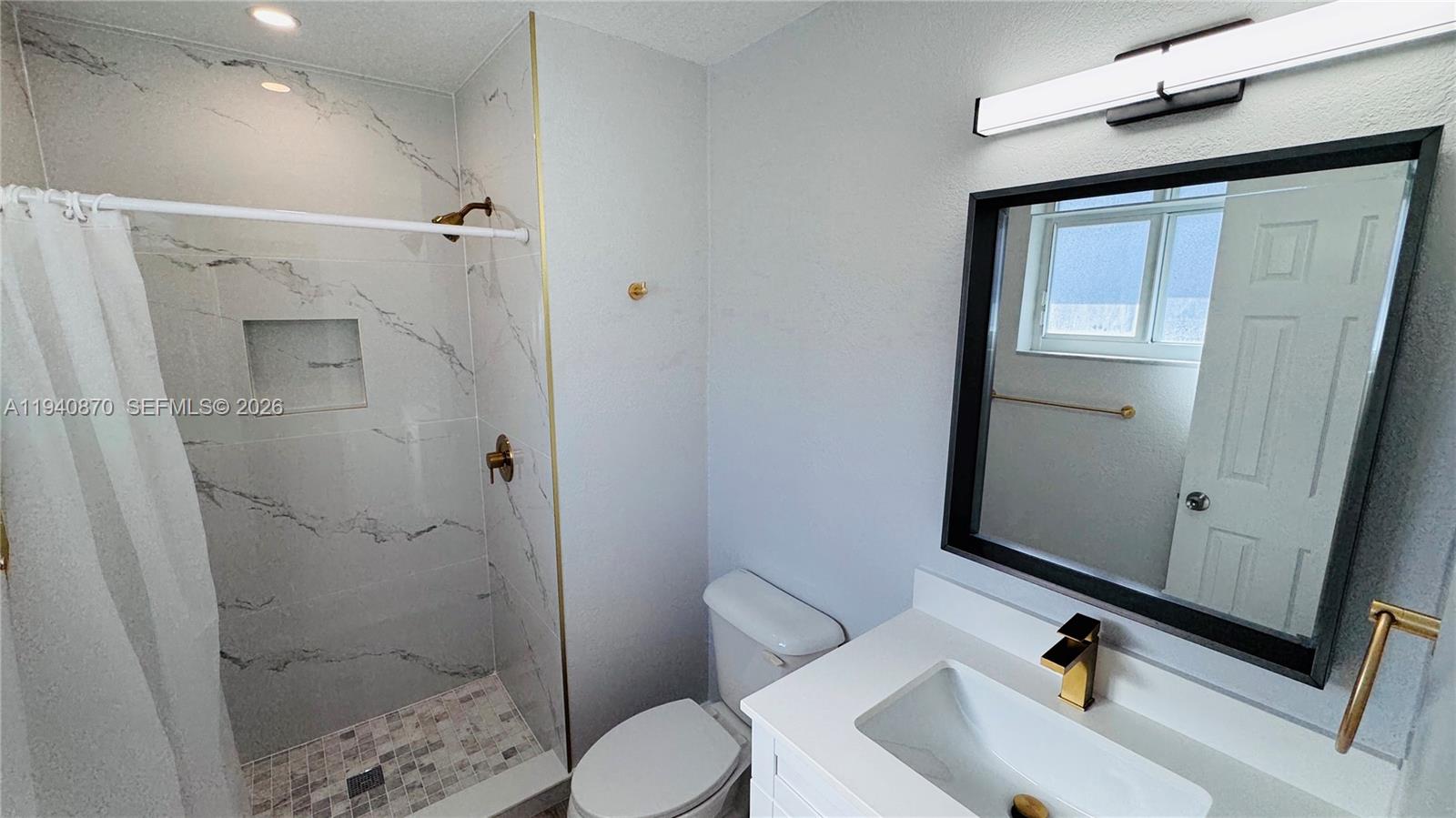 808 Northeast 2nd Street, Unit A Hallandale Beach, FL 33009 - Photo 7 of 11 a bathroom with a sink a toilet and shower