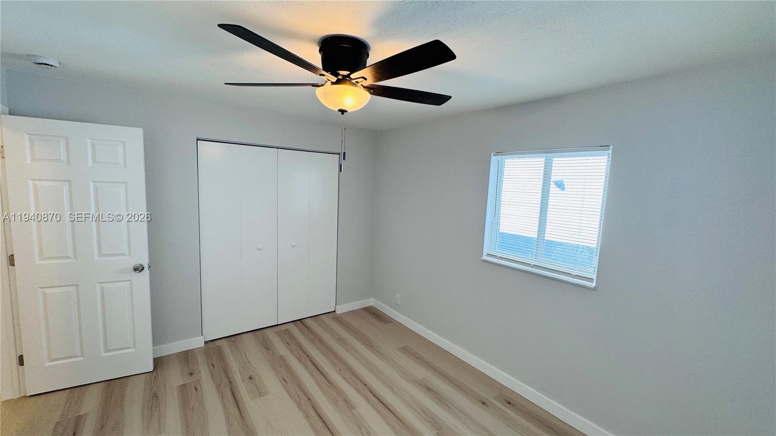 808 Northeast 2nd Street, Unit A Hallandale Beach, FL 33009 - Photo 8 of 11 a view of an empty room with wooden floor and a ceiling fan