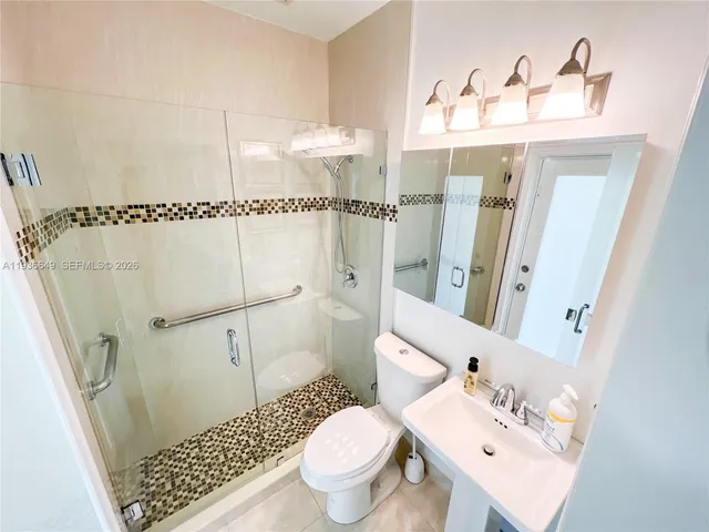 a bathroom with a sink toilet and shower