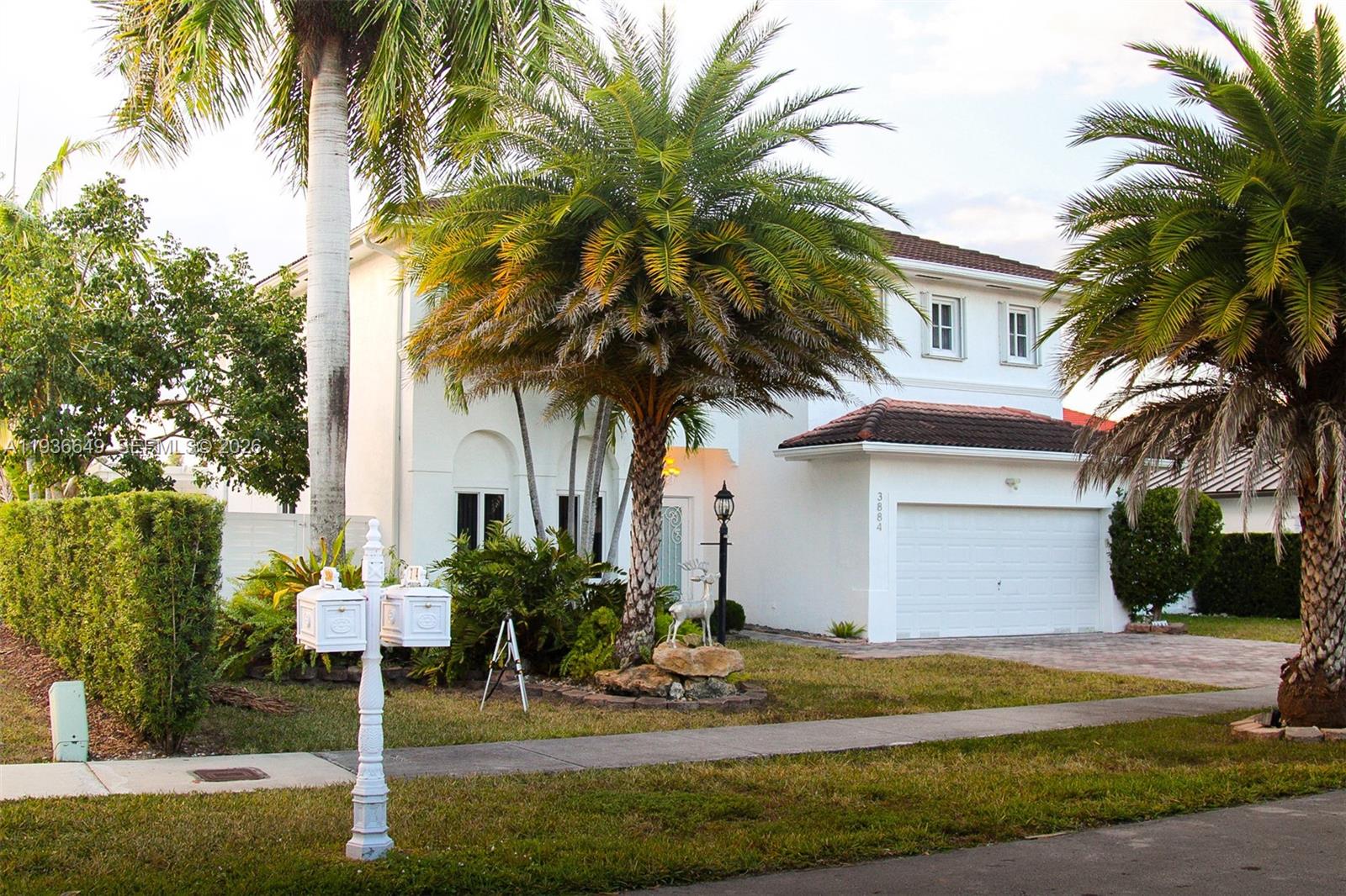 3884 Southwest 150th Court Miami, FL 33185 - Photo 2 of 45 a palm tree sitting in front of a house with a yard