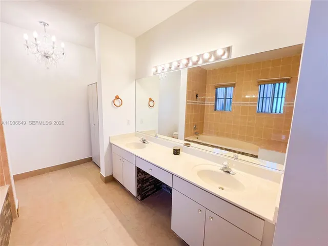 a bathroom with a tub sink and mirror