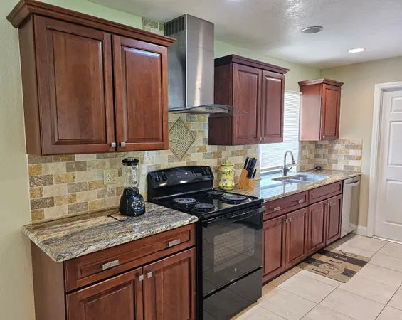 a kitchen with stainless steel appliances granite countertop a stove a refrigerator and a sink