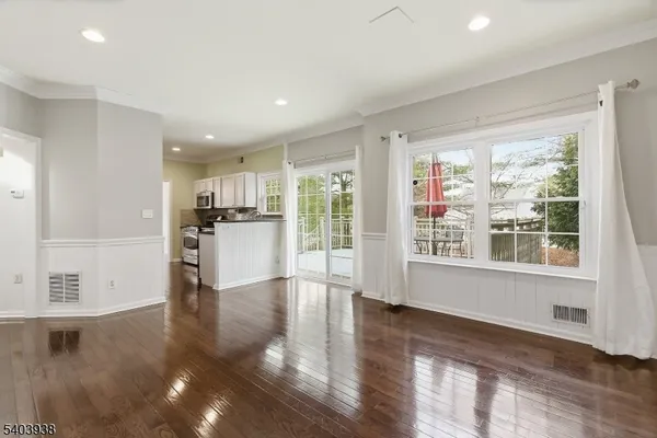 a view of a kitchen with a refrigerator wooden floor and a kitchen