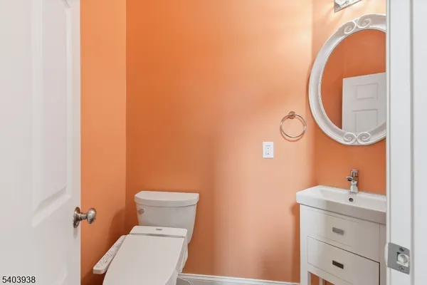 a bathroom with a sink mirror vanity and toilet