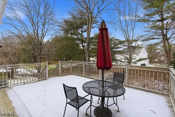 a view of a roof deck with table and chairs and a barbeque