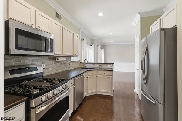 a kitchen with stainless steel appliances a sink a stove a microwave and cabinets
