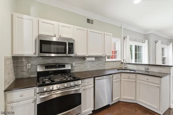a kitchen with granite countertop white cabinets and appliances