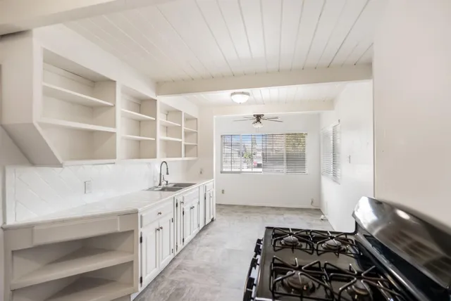 a kitchen with a sink and a stove top oven