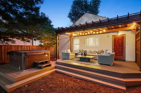 a backyard of a house with barbeque oven and outdoor seating
