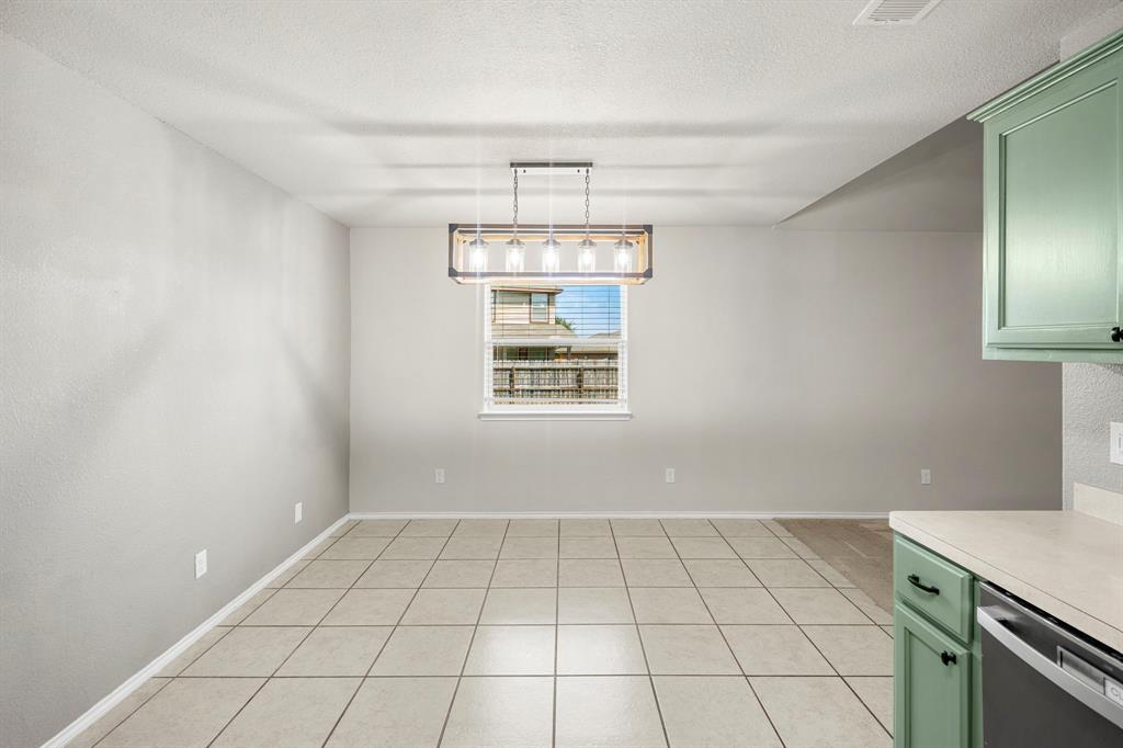 10620 Granada Drive Waco, TX 76708 - Photo 16 of 38 Spacious room featuring tile flooring, a window with blinds, and a multi-bulb chandelier