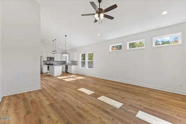a view of empty room with wooden floor and window