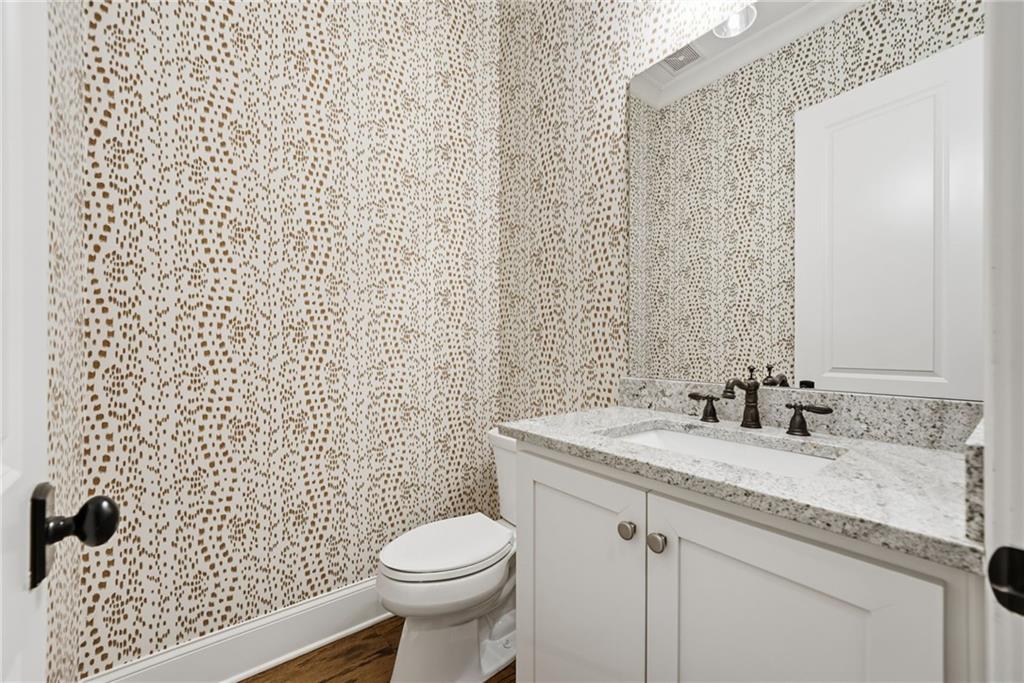 2755 Rustic Lk Terrace Cumming, GA 30041 - Photo 37 of 141 a bathroom with a granite countertop toilet a sink and a mirror