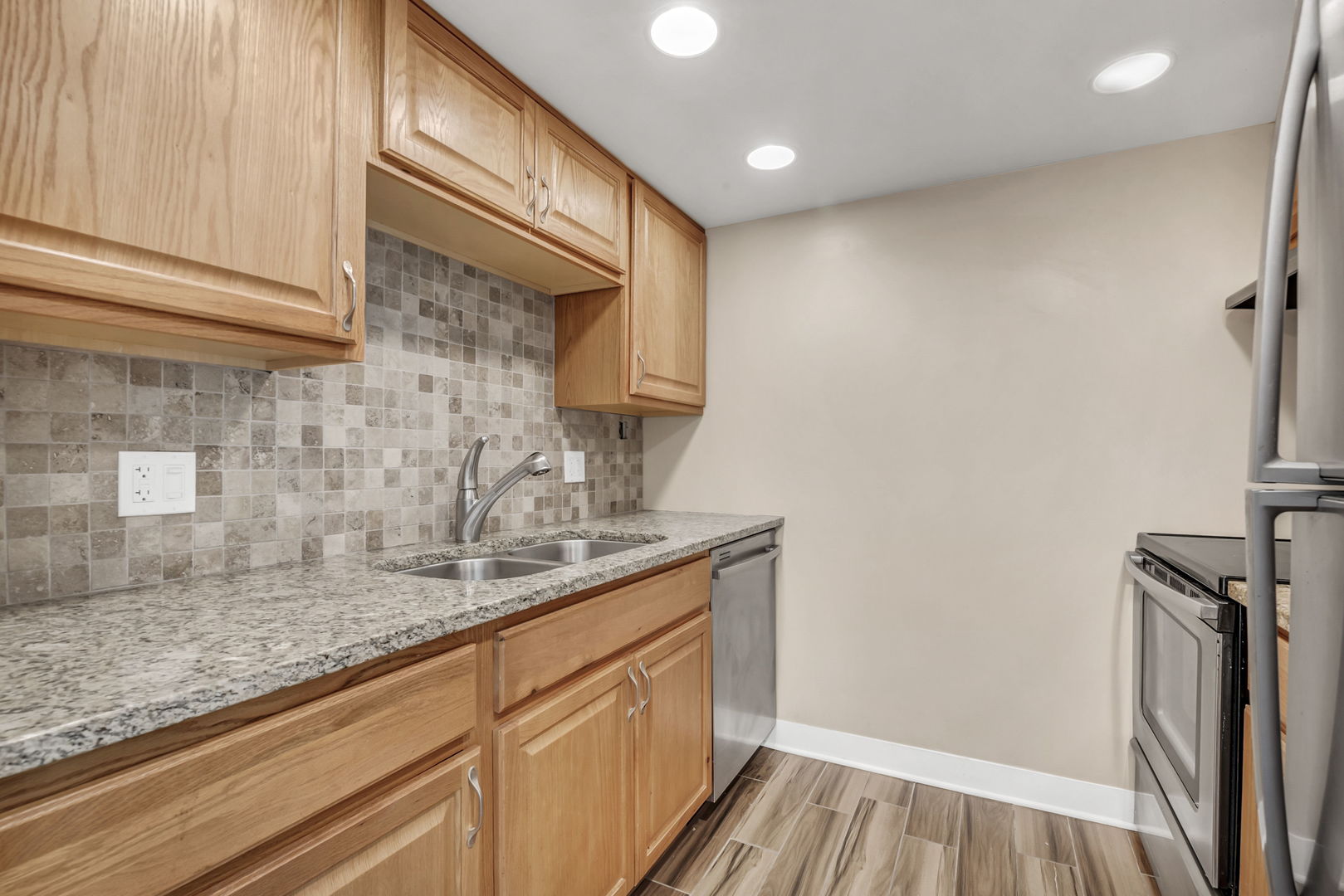 1 Renaissance Place, Unit 911 Palatine, IL 60067 - Photo 11 of 17 a kitchen with granite countertop a sink a stove and cabinets