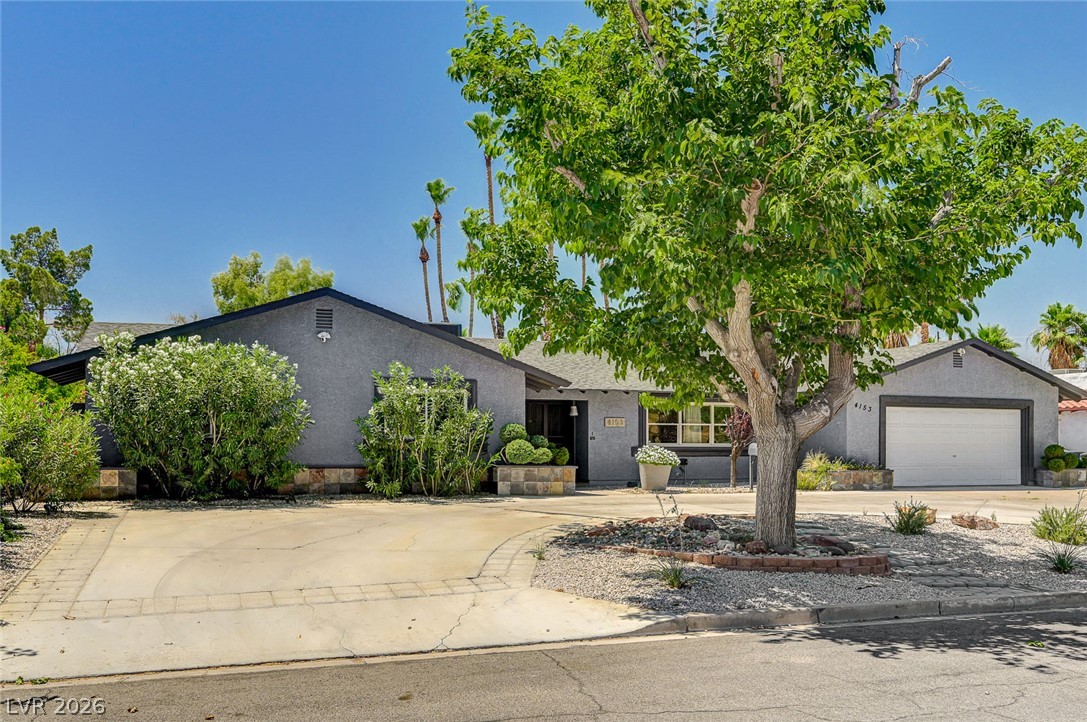 4153 Woodcrest Road Las Vegas, NV 89121 - Photo 4 of 58 A welcoming front exterior with mature landscaping and a well-maintained driveway.